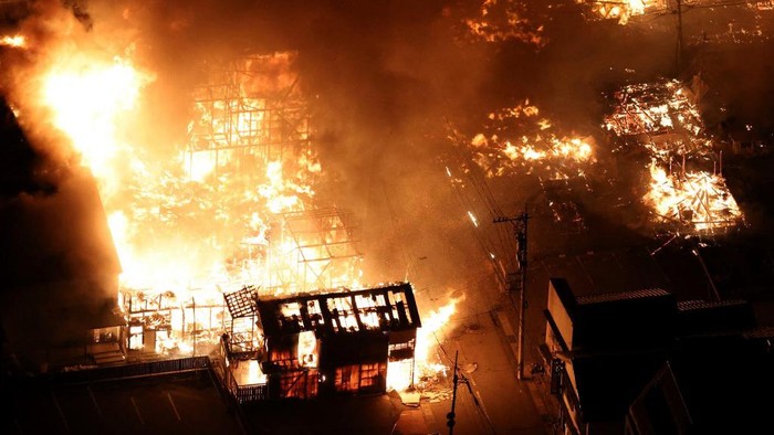 This aerial photo shows buildings burning in the city of Wajima, Ishikawa prefecture on January 1, 2024, after a major 7.5 magnitude earthquake struck the Noto region in Ishikawa prefecture in the afternoon. Tsunami waves over a metre high hit central Japan on January 1 after a series of powerful earthquakes that damaged homes, closed highways and prompted authorities to urge people to run to higher ground. (Photo by Yomiuri Shimbun / AFP) / Japan OUT / NO ARCHIVES - MANDATORY CREDIT: Yomiuri Shimbun