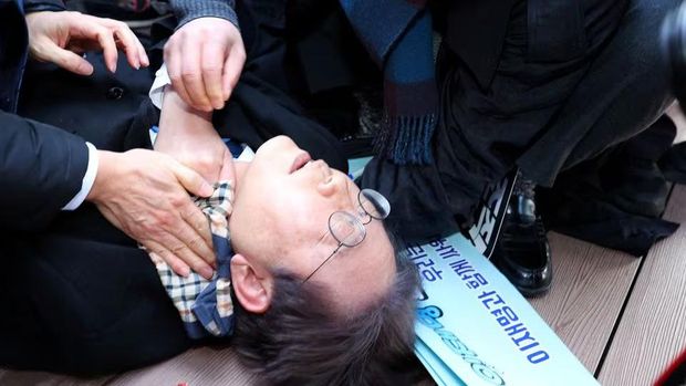 South Korea's opposition party leader Lee Jae-myung falls after being attacked by an unidentified man during his visit to Busan, South Korea, January 2, 2024. Yonhap via REUTERS Acquire Licensing Rights