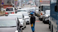 Seorang polisi mengatur antrean kendaraan yang akan membeli bahan bakar di sebuah SPBU setelah gempa bumi, di Wajima, prefektur Ishikawa, Jepang 2 Januari 2024.