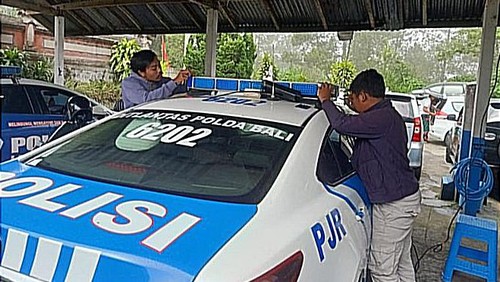 Pemasangan kaca film pada lampu rotator kendaraan Ditlantas Polda Bali.