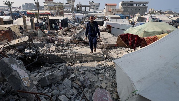 Palestinian man Hamada Abu Sleyma, whose wife, all his 6 children and two grandchildren were killed in an Israeli strike that destroyed his house, stands near a tent in which he shelters on the rubble of his house, in Rafah in the southern Gaza Strip, January 1, 2024. REUTERS/Ibraheem Abu Mustafa