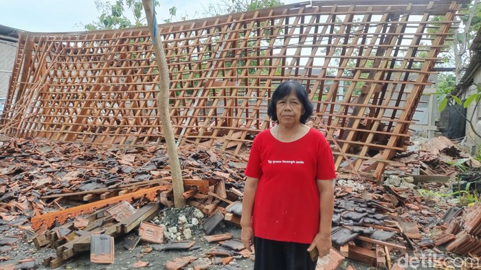 Sumaryati berdiri di depan rumahnya yang roboh akibat angin kencang di Wonosari, Gunungkidul, Rabu (3/1/2024).