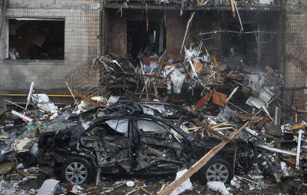 Petugas pemadam kebakaran berupaya memadamkan api di gedung apartemen yang hancur pasca serangan Rusia di Kyiv, Ukraina, Selasa, 2 Januari 2024. (AP Photo/Efrem Lukatsky)
