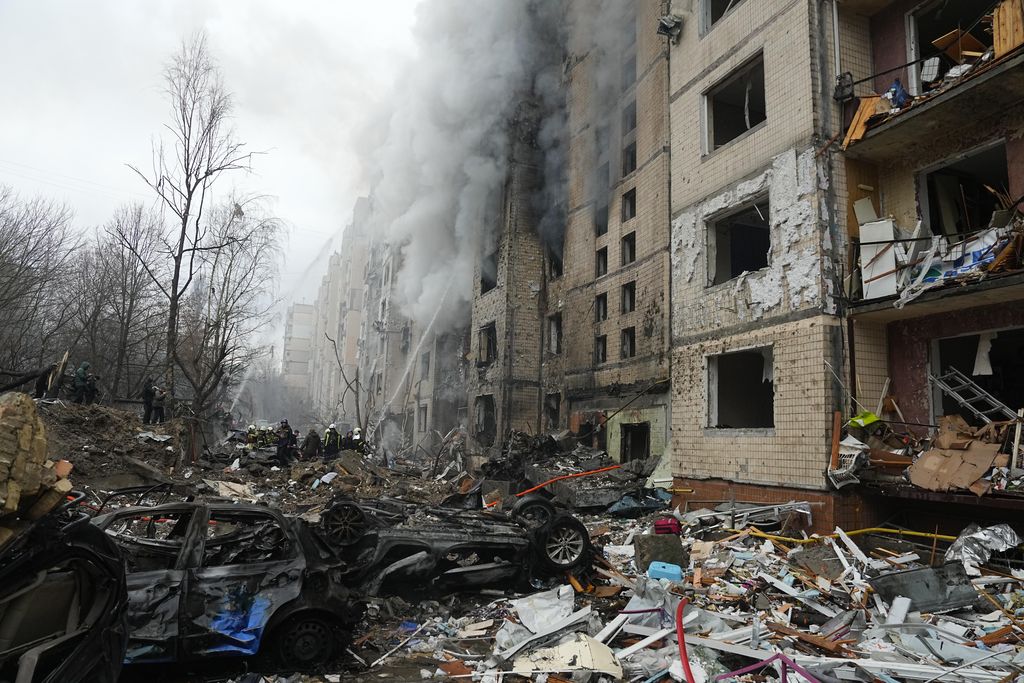 Petugas pemadam kebakaran berupaya memadamkan api di gedung apartemen yang hancur pasca serangan Rusia di Kyiv, Ukraina, Selasa, 2 Januari 2024. (AP Photo/Efrem Lukatsky)