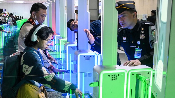 Bandara Soekarno-Hatta Tambah Autogate Imigrasi, Begini Potretnya Calon penumpang pesawat memindai paspor dan pengenalan wajah di pintu otomatis (autogate) pemeriksaan imigrasi, Terminal 3 Bandara Internasional Soekarno Hatta, Tangerang, Banten, Rabu (3/1/2024). Direktorat Jenderal Imigrasi Bandara Soekarno Hatta meresmikan 68 autogate baru di Terminal 3, dan 10 autogate baru di Terminal 2 untuk mempermudah dan memperketat layanan pemeriksaan imigrasi bagi penumpang. ANTARA FOTO/Sulthony Hasanuddin/wra.