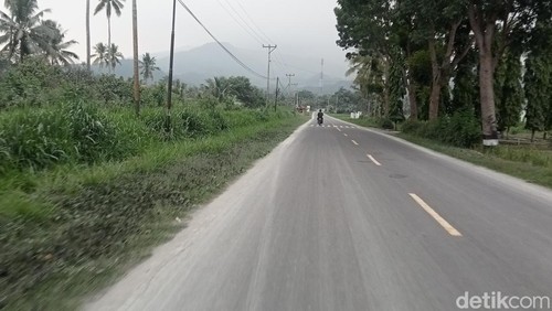 Keterangan Jalan Trans Larantuka-Maumere yang diguyur abu vulkanik Gunung Lewotobi.