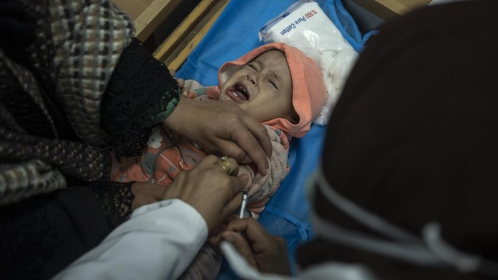Palestinians line up with their children to receive vaccination against diseases, which recently entered Gaza as part of aid, in Rafah, southern Gaza Strip, Tuesday, Jan. 2, 2024. The vaccination was not available due to the war and most children are about 3 months late for their vaccination. (AP Photo/Fatima Shbair)
