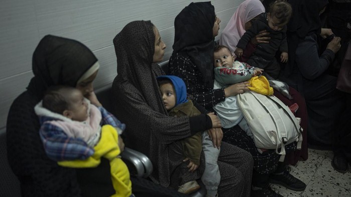 Palestinians line up with their children to receive vaccination against diseases, which recently entered Gaza as part of aid, in Rafah, southern Gaza Strip, Tuesday, Jan. 2, 2024. The vaccination was not available due to the war and most children are about 3 months late for their vaccination. (AP Photo/Fatima Shbair)
