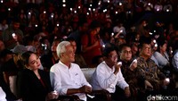 Ganjar dan Mahfud kompak mengenakan kemeja putih. Mereka duduk bersebelahan.