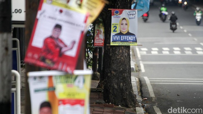 Alat peraga kampanye (APK) seperti spanduk, poster, dan sejenisnya milik para caleg terpaku di pohon. Tidak hanya satu dua pohon, tetapi menjamur di mana-mana.