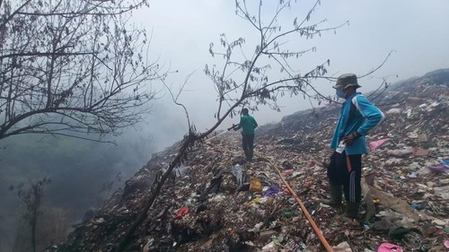 Situasi TPA Bengkala, Rabu (3/1/2024). Petugas masih berupaya untuk memadamkan kepulan asap dengan menyirami air. (Made Wijaya Kusuma)
