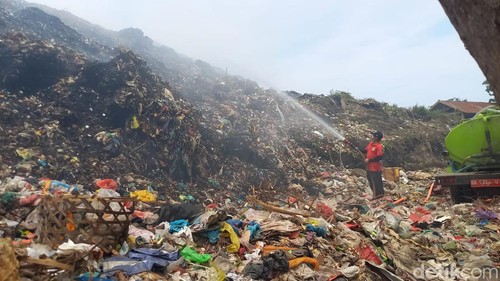 Situasi TPA Bengkala, Rabu (3/1/2024). Petugas masih berupaya untuk memadamkan kepulan asap dengan menyirami air. (Made Wijaya Kusuma)