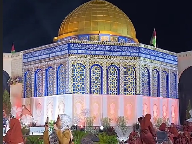 Acara pernikahan ini mengusung tema yang unik sehingga mencuri atensi warganet di TikTok. Pengantin mengusung tema Palestina dan menghadirkan replika Masjid Al Aqsa sebagai dekorasi. Foto: Dok. TikTok @ayidh_mua.