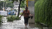 Seorang warga melintasi genangan di Kemang usai diguyur hujan.