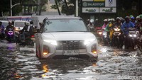 Sejumlah kendaraan roda empat melambatkan laju kecepatan. Sebagian pengendara ada yang mendorong motornya dan menepi.