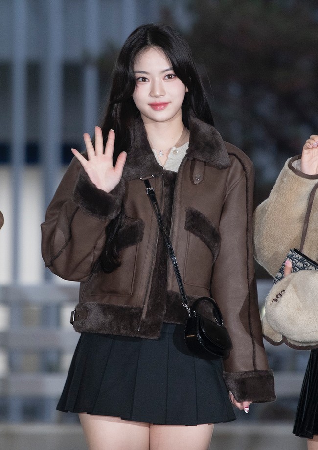 Di samping Sumin, ada Isa STAYC yang memilih gaya serupa dengan model coat berbeda. Penampilannya dipermanis dengan sling bag dan platform boots serasi. Foto: dok. Twitter @STAYCUniverse