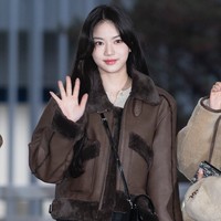 Di samping Sumin, ada Isa STAYC yang memilih gaya serupa dengan model coat berbeda. Penampilannya dipermanis dengan sling bag dan platform boots serasi. Foto: dok. Twitter @STAYCUniverse