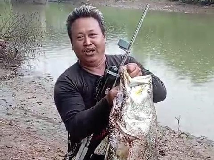 Pemancing menangkap ikan berukuran besar dari bawah jembatan Sungai Tayu, Pati, Rabu (3/1/2024).