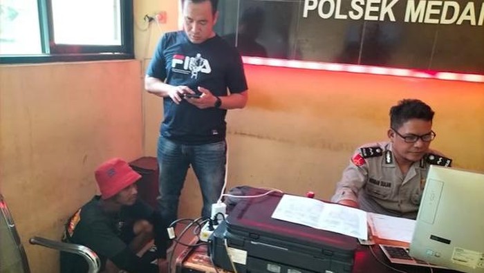 Jukir yang kena semprot Bobby (pakai topi merah sedang jongkok) saat berada di kantor polisi. (Foto: Instagram @bobbynst)