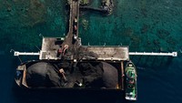 Pekerja mengoperasikan alat berat saat bongkar muat batu bara ke dalam truk yang didatangkan dari Samarinda di Pelabuhan PLTU Tidore Kepulauan, Maluku Utara, Kamis (4/1/2023).  