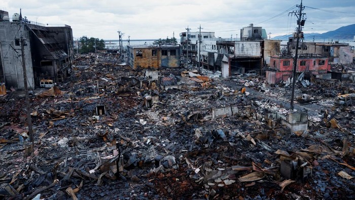 Kondisi Kota di Jepang yang Terbakar Imbas Gempa Bumi A man makes his way along Asaichi-dori street, which burned down due to a fire following an earthquake, in Wajima, Japan, January 4, 2024. REUTERS/Kim Kyung-Hoon