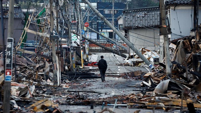 A man makes his way along Asaichi-dori street, which burned down due to a fire following an earthquake, in Wajima, Japan, January 4, 2024. REUTERS/Kim Kyung-Hoon