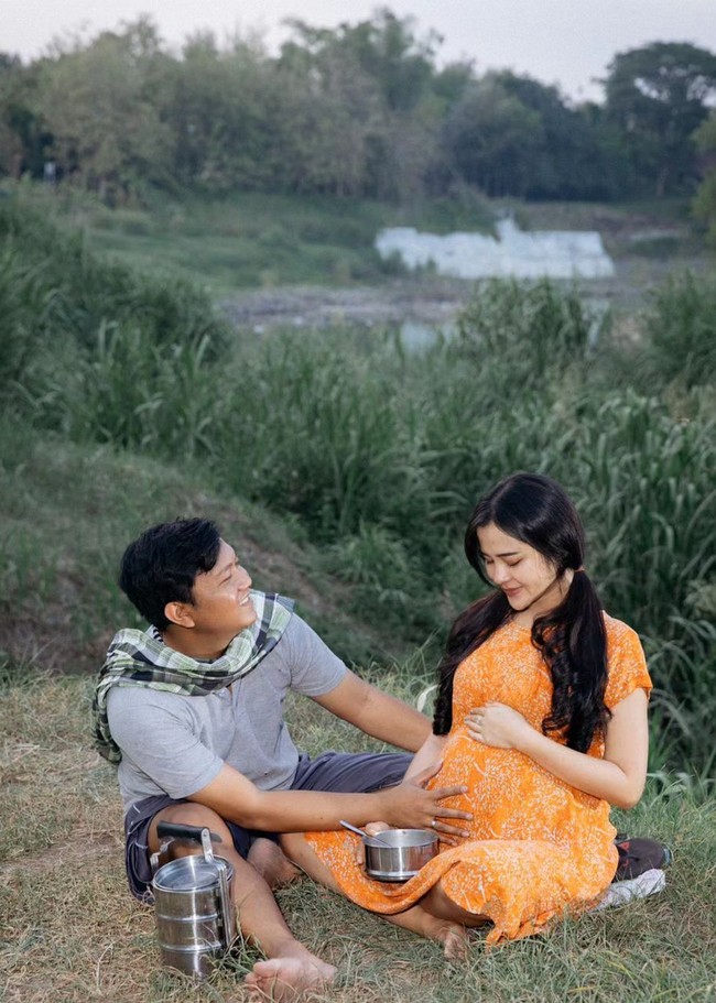 Model sekaligus selebgram ini tampak memakai daster warna oranye. Wajahnya dipulas makeup tipis dan rambut dikuncir dua bak kembang desa. Foto: Instagram/@bellabonita_r.a