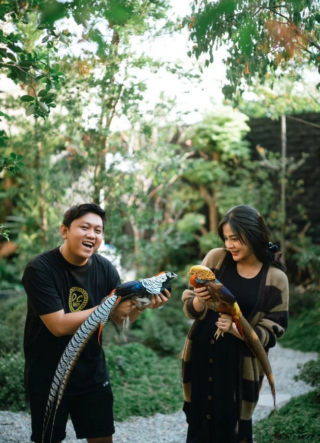 Denny dan Bella sama-sama memakai busana casual. Mereka terlihat bercengkerama dengan dua ekor burung. Foto: Instagram/@bellabonita_r.a
