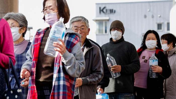 Musim Dingin, Korban Gempa Jepang Antre Ambil Air Panas Evacuees stand in a line to receive water from a water tank car at an evacuation center, in the aftermath of an earthquake, in Wajima, Ishikawa Prefecture, Japan, January 4, 2024. REUTERS/Kim Kyung-Hoon