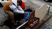 Seseorang mengambil air dari pemandian air panas gratis untuk hewan peliharaan untuk digunakan di toilet, setelah gempa bumi, di Wajima, Prefektur Ishikawa, Jepang, Kamis (4/1/2024).  