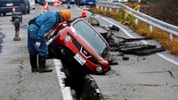 Jalanan yang retak itu membuat mobil yang melintas terperosok. Reuters/Kim Kyung-Hoon.