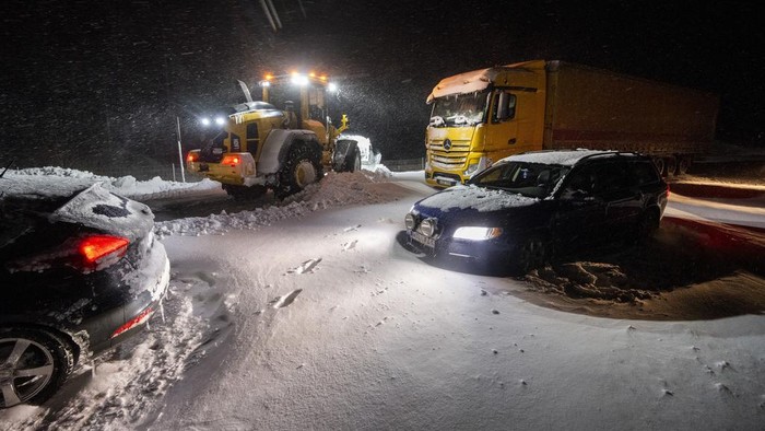 CORRECTS YEAR TO 2024   Snow is cleared with wheel loaders as cars and trucks are recovered and people are evacuated with the Home Guard's tracked vehicle at Ekeröd on the E22 between Hörby and Kristianstad in southern Sweden, Thursday, Jan. 4, 2024. Up to 300 cars stuck in a queue due to large amounts of snow that fell on the roadway and limited access, according to the police. (Johan Nilsson/TT News Agency via AP)