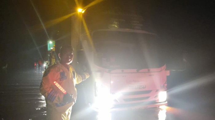 Satlantas Polres Pelalawan mengawal mobil pengangkut logistik pemilu melintasi banjir di Jalintim. (Dok Polres Pelalawan)