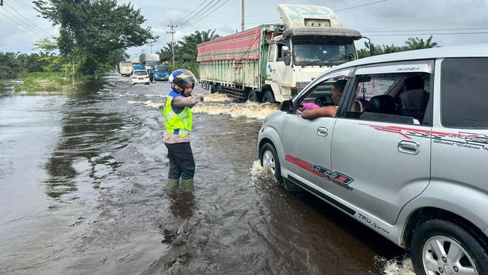 Satlantas saat mengatur lalu lintas di lokasi banjir (Dok Satlantas Polres Pelalawan)