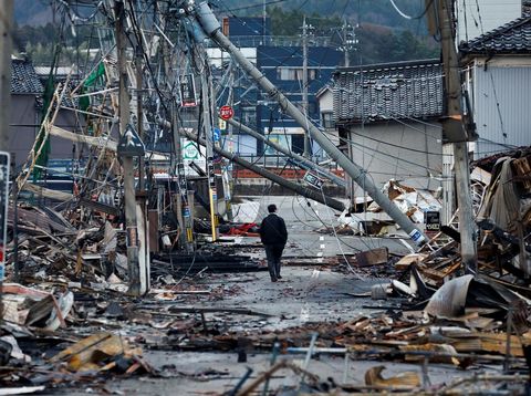 Seorang pria berjalan di sepanjang Jalan Asaichi-dori yang terbakar akibat gempa bumi, di Wajima, Jepang, 4 Januari 2024. (REUTERS/Kim Kyung-Hoon)