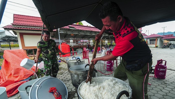 Prajurit TNI Bekang II/2. B Jambi memasak nasi di tempat pengungsian swadaya Simpang Tiga Rawang, Sungai Penuh, Jambi, Kamis (4/1/2024). Prajurit TNI mendirikan dapur umum di tempat pengungsian guna memberikan dukungan kepada lebih dari 600 orang warga korban banjir yang masih mengungsi di tempat itu. ANTARA FOTO/Wahdi Septiawan/nym.