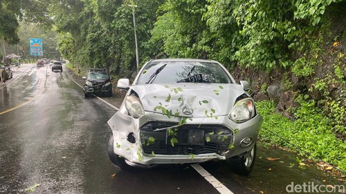 Dua mobil tertimpang pohon tumbang di Jalan Raya Senggigi, Lombok Barat.