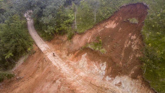 Jalan di Kerinci Jambi Tertimbun Longsor, Begini Kondisinya Foto udara pengendara melintasi jalan yang tertimbun material longsor di Pungut Tengah, Kerinci, Jambi, Jumat (5/1/2024). Jalan yang menghubungkan beberapa desa di Kecamatan Siulak Mukai dengan Air Hangat Timur itu tertimbun longsor sejak Minggu (31/1/2023) yang hanya bisa dilintasi kendaraan roda dua, dan pemerintah Kabupaten Kerinci telah menetapkan status tanggap darurat banjir dan longsor hingga 7 Januari mendatang. ANTARA FOTO/Wahdi Septiawan/aww.