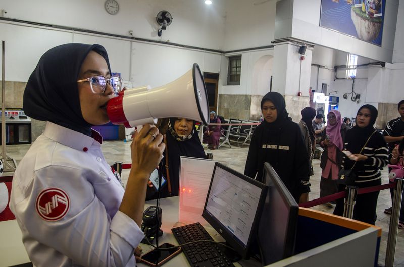 Petugas memberikan informasi kepada penumpang yang akan berangkat di pintu kereta lokal Stasiun Bandung, Bandung, Jawa Barat, Jumat (5/1/2024). PT. KAI melakukan penyesuaian jadwal dan pengalihan tujuan jalur selatan hanya sampai di Stasiun Rancaekek untuk penumpang kereta yang terdampak kecelakaan antara kereta KA Turangga dan keret Commuterline Bandung Raya. ANTARA FOTO/Novrian Arbi/YU