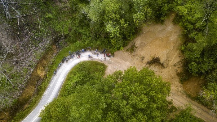 Warga melintasi jalan penghubung Kecamatan Siulak Mukai dengan Air Hangat Timur yang tertimbun longsor di Pungut Hilir, Kerinci, Jambi, Jumat (5/1/2024). Longsor susulan yang terjadi pada Kamis (4/1) malam itu akibat hujan deras yang mengakibatkab runtuhnya tebing perbukitan sehingga menutupi akses jalan dan mengisolasi beberapa desa di daerah itersebut. ANTARA FOTO/Wahdi Septiawan/Spt.