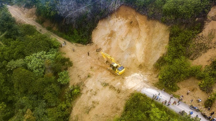 Warga melintasi jalan penghubung Kecamatan Siulak Mukai dengan Air Hangat Timur yang tertimbun longsor di Pungut Hilir, Kerinci, Jambi, Jumat (5/1/2024). Longsor susulan yang terjadi pada Kamis (4/1) malam itu akibat hujan deras yang mengakibatkab runtuhnya tebing perbukitan sehingga menutupi akses jalan dan mengisolasi beberapa desa di daerah itersebut. ANTARA FOTO/Wahdi Septiawan/Spt.