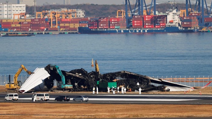 Pesawat yang Terbakar Usai Tabrakan di Bandara Haneda Mulai Dibersihkan Officials remove the wreckage of a burnt Japan Airlines (JAL) Airbus A350 plane after a collision with a Japan Coast Guard aircraft at Haneda International Airport in Tokyo, Japan January 5, 2024. REUTERS/Issei Kato