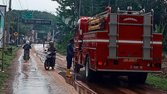 Petugas membersihkan lumpur di jalan Kampir, Desa Wangandowo, Kecamatan Bojong, Kabupaten Pekalongan, Rabu (3/1/2024),