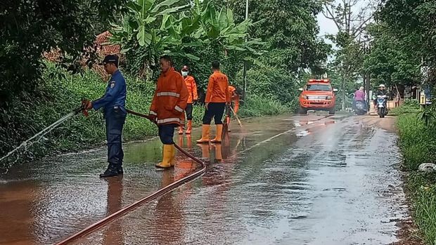 Petugas membersihkan lumpur di jalan Kampir, Desa Wangandowo, Kecamatan Bojong, Kabupaten Pekalongan, Rabu (3/1/2024),