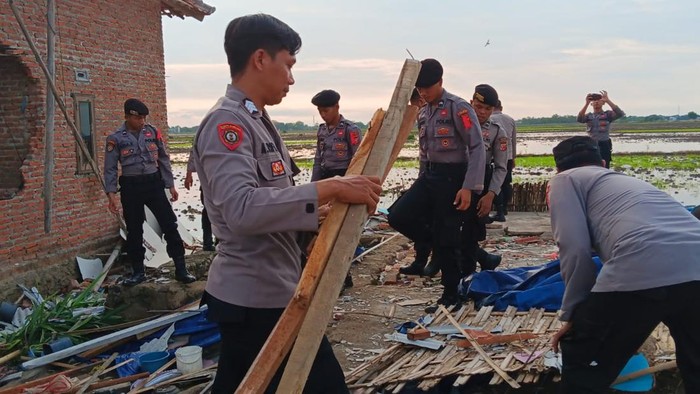 Polisi membersihkan puing bangunan rusak akibat angin puting beliung di Indramayu