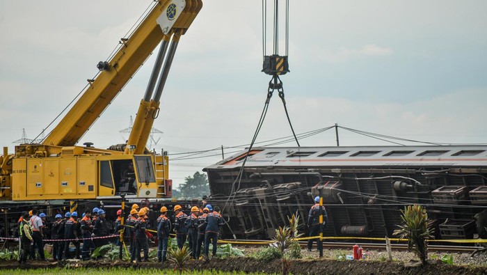 Potret Alat Berat Dikerahkan Evakuasi Kereta Kecelakaan di Cicalengka Petugas mengoperasikan alat berat untuk mengevakuasi rangkaian kereta yang mengalami kecelakaan di Cicalengka, Kabupaten Bandung, Jawa Barat, Jumat (5/1/2024). Selama proses evakuasi berlangsung, PT KAI mengalihkan jalur kereta api menuju selatan ke jalur utara . ANTARA FOTO/Raisan Al Farisi/Spt.