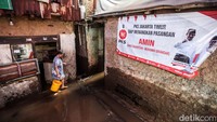 Warga melintas di gang yang masih kebanjiran. 
