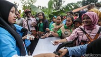 Emak-emak tampak antusias menukar kupon dengan paket susu dll yang dibagikan.