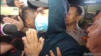 Saipul Jamil keluar Polsek Tambora dengan menggunakan hoodie hitam dan masker. Dia menutup bagian kepalanya dengan topi dan juga kupluk hoodie. Foto: Ahsan/detikHOT