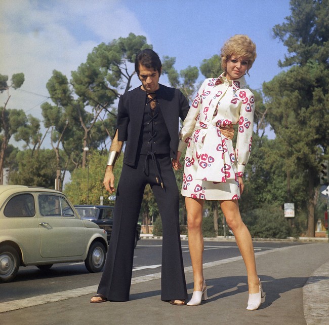 Sepasang pria dan wanita bergaya di jalanan Roma, Italia, pada 1969. Buku Fashion The Whole Story (Thames & Hudson, 2013) mencatat era 1960-an sebagai momentum kebangkitan busana pria yang dipicu oleh gejolak politik dan ekonomi. (Foto: AP Photo/Mario Torrisi)